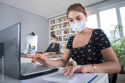 young businesswoman in face mask in office