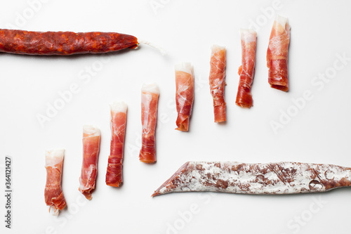 Rolls of spanish ham, chorizo and fuet sausages photo