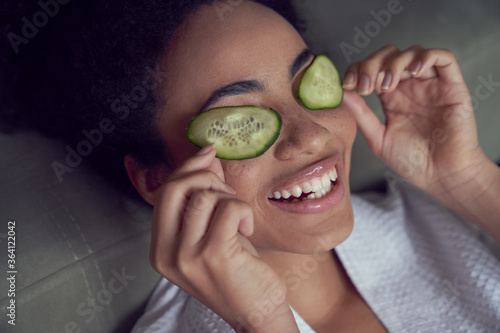 Jolly young woman with natural vegetable face mask