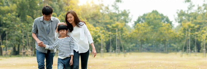 Happy young family spending time together outside, Thai Asian parents take kid to relax in park or garden far away from busy people and covid19, enjoy life and happiness