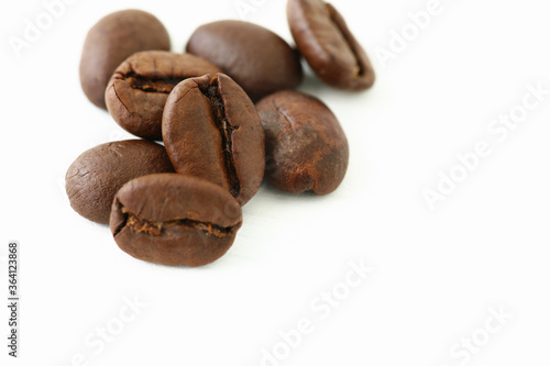 Roasted coffee beans on white background with copy space.