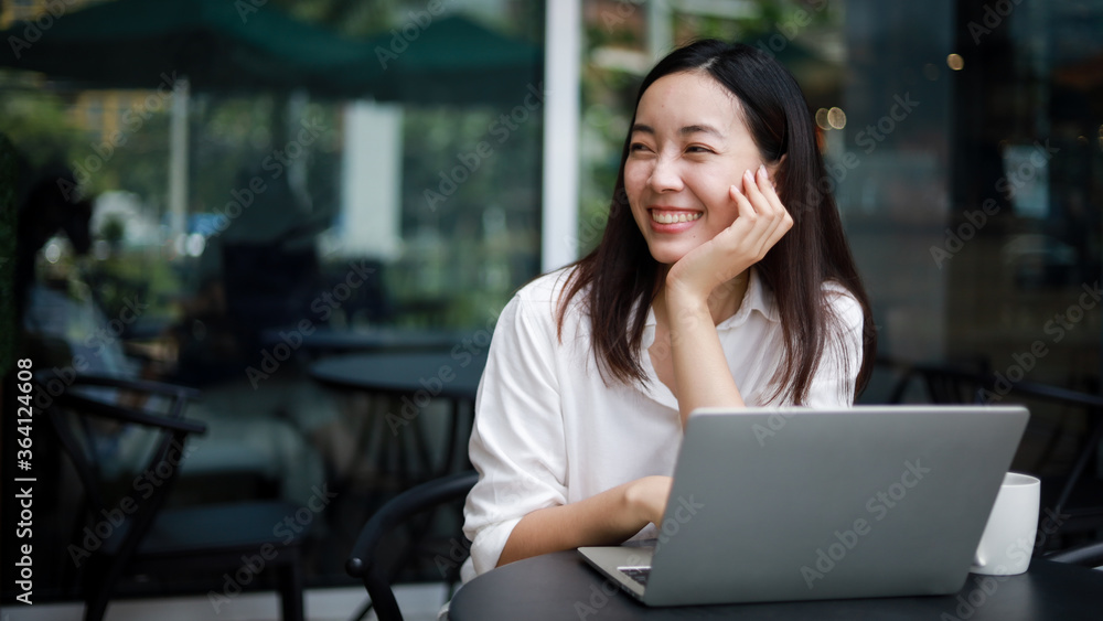 Asian woman working with computer laptop and drinking coffee in coffee shop cafe smile and happy face Asian woman working with computer laptop and drinking coffee in coffee shop cafe smile and happy face