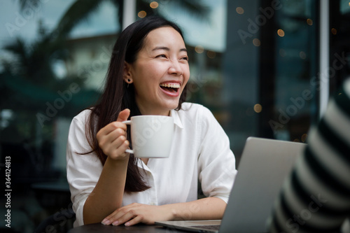 Wallpaper Mural Asian woman working with computer laptop and drinking coffee in coffee shop cafe smile and happy face and talking with friend Torontodigital.ca