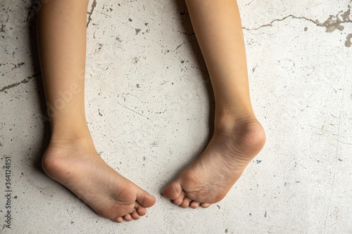 Close Up of a little girl's legs and feet Stand On a Cement background