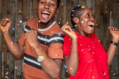 young african people feeling excited and happy, celebrating with confetti