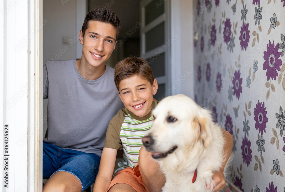 Two boys with a dog in doorway of their house
Two boys with a dog in doorway of their house