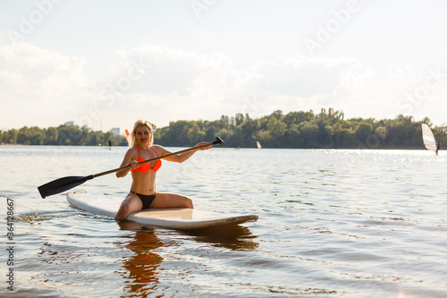 Action Shot of Young Woman on Paddle Board © Angelov