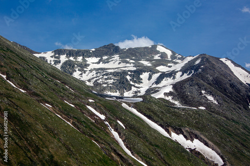 Snowy mountains that begin to melt and become green with spring and around