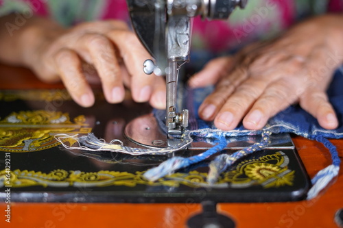 Close up woman hands sewing Traditional prayer mat with old sewing machine