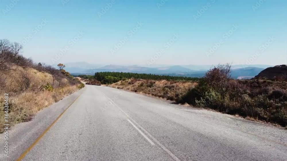driving on tarmac road in Africa with trees and grassland winter clear skies dry out of focus with grain driving on tarmac road in Africa with trees and grassland winter clear skies dry out of focus with grain