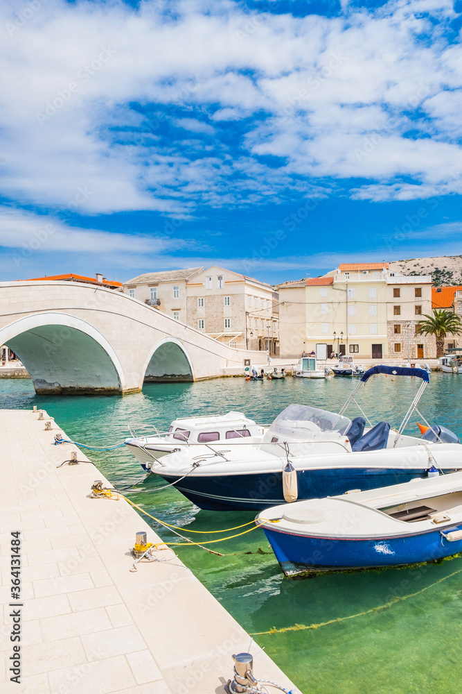 Old town of Pag on Adriatic sea, Dalmatia, Croatia, marina and old stone bridge. Popular tourist destination.