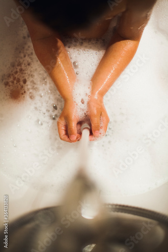 Boy washing his hands during his bathtime