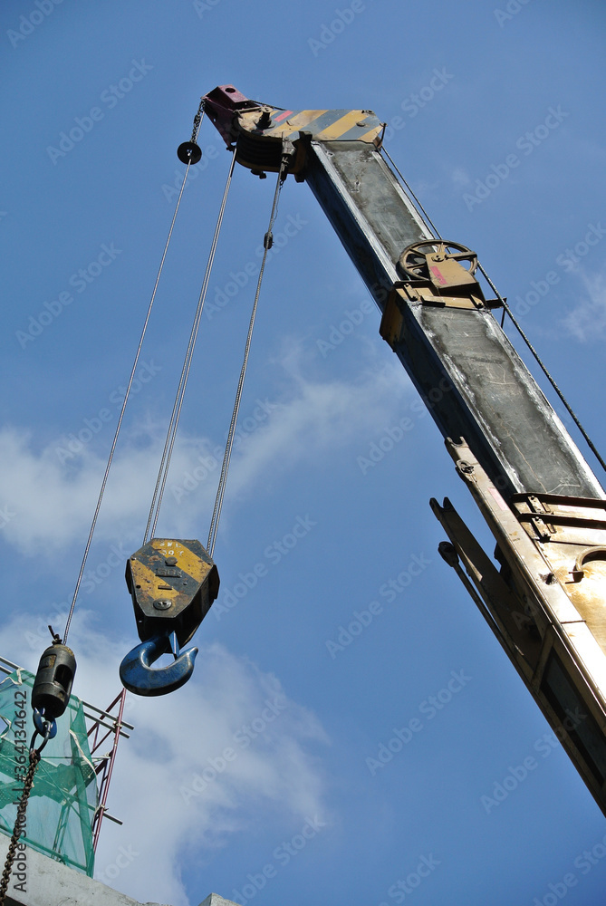 JOHOR, MALAYSIA -FEBRUARY 26, 2016: Mobile crane boom with hooks and scale weight above blue sky. The boom used to lifting heavy load. JOHOR, MALAYSIA -FEBRUARY 26, 2016: Mobile crane boom with hooks and scale weight above blue sky. The boom used to lifting heavy load.