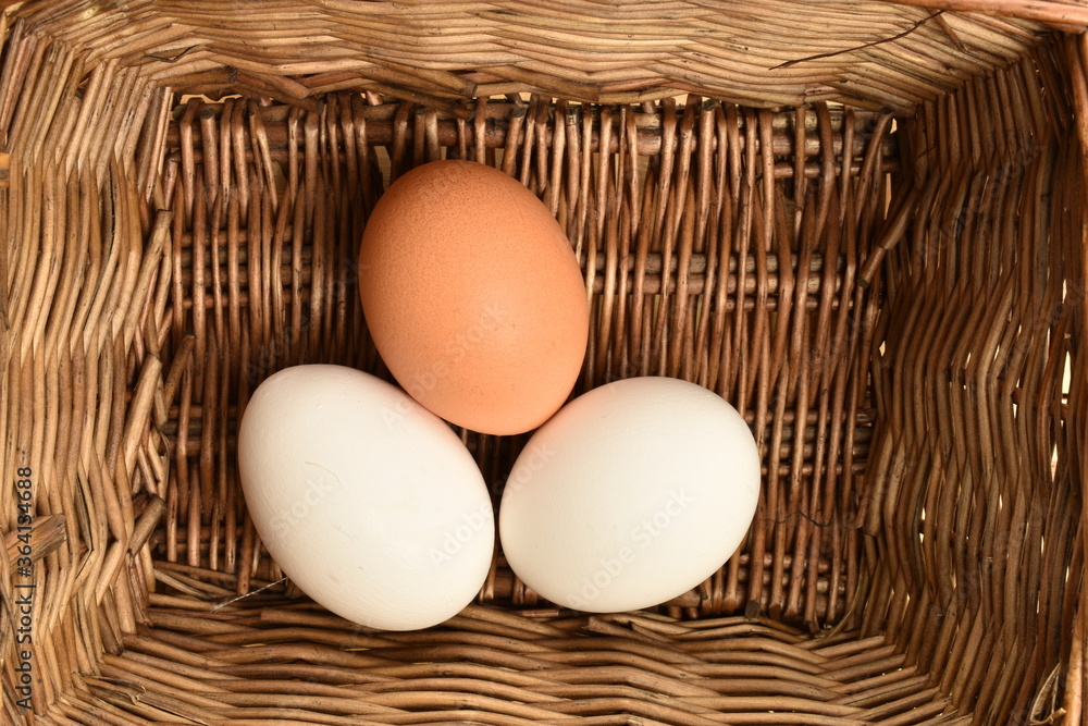 Several chicken eggs, in a basket, close-up Several chicken eggs, in a basket, close-up