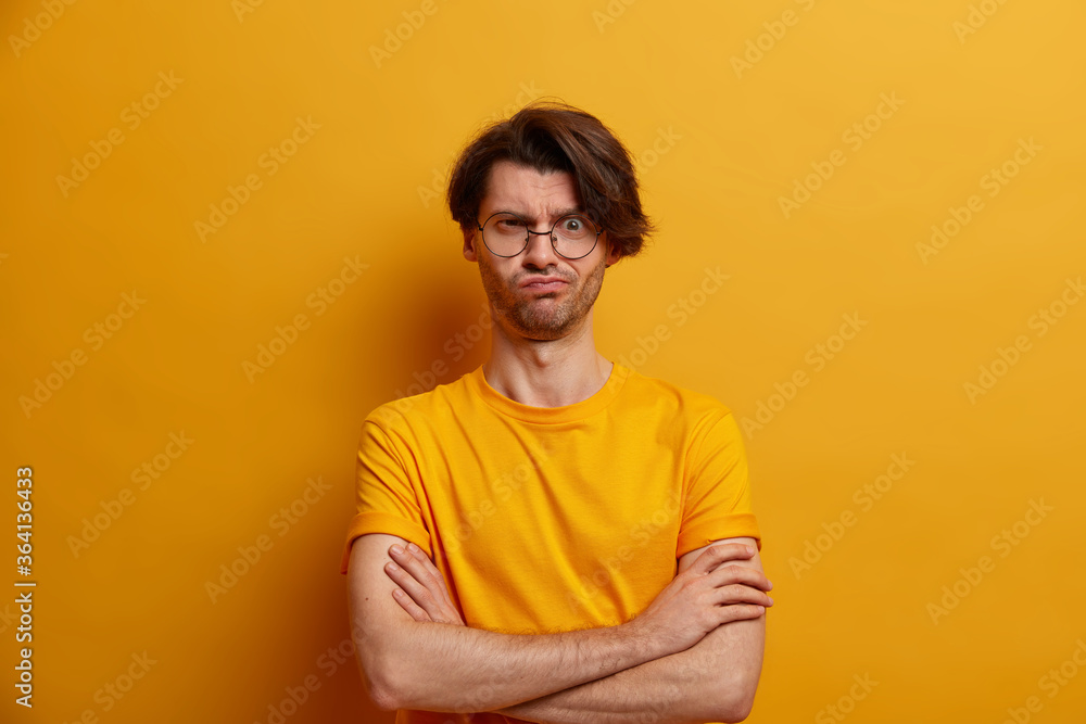Displeased man smirks face and crosses hands over chest, dislikes what he hears, irritated to stand for long time in queue, says how long it will continue, being not in mood, expresses disagreement Displeased man smirks face and crosses hands over chest, dislikes what he hears, irritated to stand for long time in queue, says how long it will continue, being not in mood, expresses disagreement