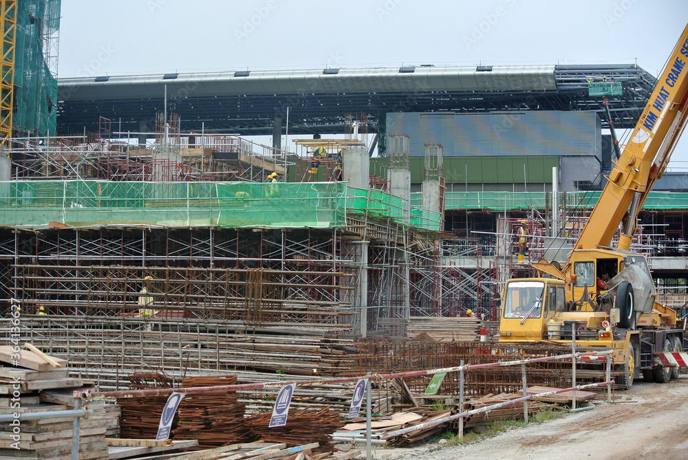Naklejka premium SERDANG, MALAYSIA -MAY 13, 2016: Construction workers working at the construction site at Serdang, Malaysia during daytime. They are wearing proper safety gear so ensure they are safe working. 