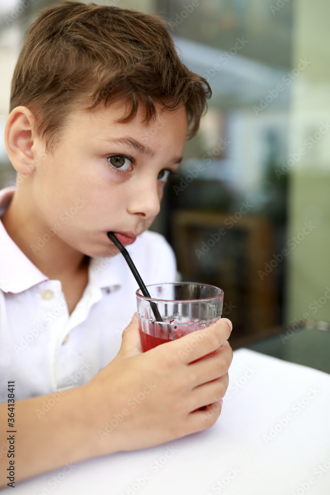 Boy has fruit drink on terrace Boy has fruit drink on terrace