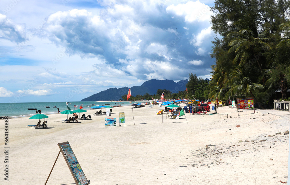 landscape view of pantai cenang beach at Langkawi Island with tourist attraction and background of blue sky and hills
