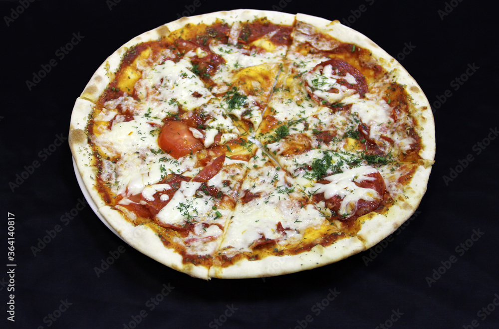  Pizza with salami sausage, tomato, syrup and dill on a white plate