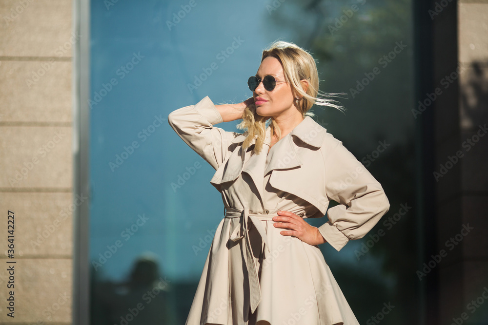 beautiful young woman in coat and sunglasses