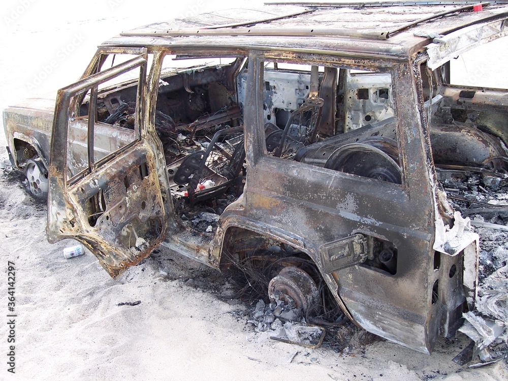 Fototapeta premium Burned up abandoned car on the beach in Cabo San Lucas Mexico 2006
