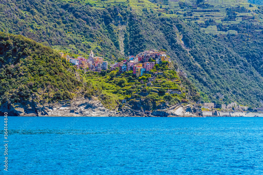 A view from the sea looking up towards the cliff top settlement of Corniglia and railway station in the summertime