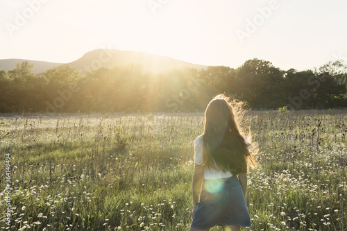 Wallpaper Mural Beauty portrait of a little girl with long hair enjoying nature outdoors, on a field with daisies. The wind blows the girl's long hair. Beautiful young girl backs closeup Torontodigital.ca