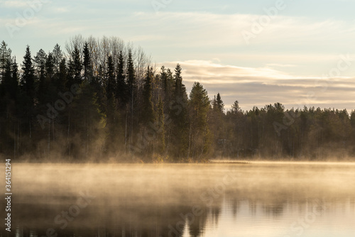 Morningmist with golden glow at a lake in Finland