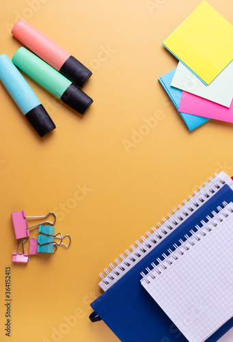 different stationary items and notebooks on the yellow background. minimalism. flat lay