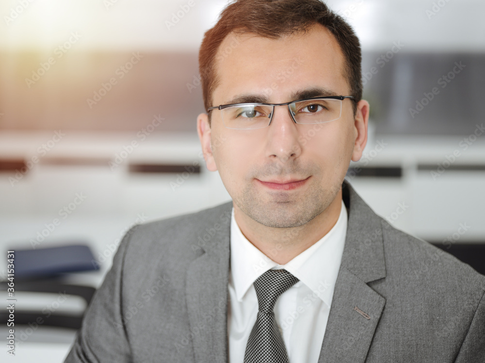 Businessman headshot in modern office. Grey blazer suits to happy smiling manager Businessman headshot in modern office. Grey blazer suits to happy smiling manager