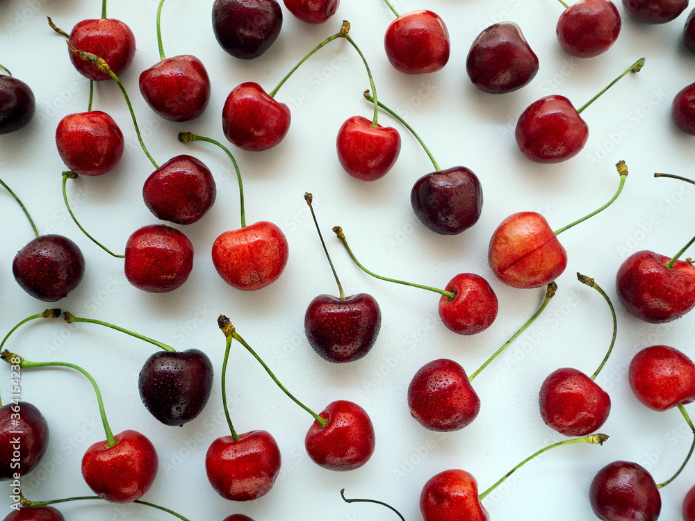 Red tasty sweet cherry isolated on a white background. Drops of water on the berries. Background with ripe cherries. Red tasty sweet cherry isolated on a white background. Drops of water on the berries. Background with ripe cherries.