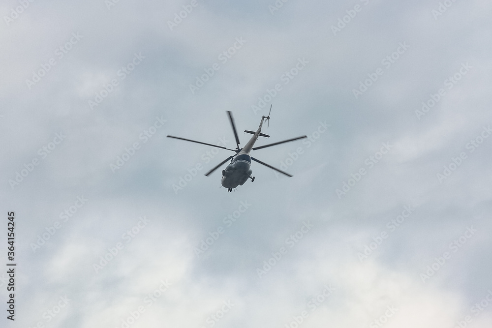 helicopter with five blades flies in the sky. View from the bottom. Fast air transport in cloudy sky. helicopter with five blades flies in the sky. View from the bottom. Fast air transport in cloudy sky.