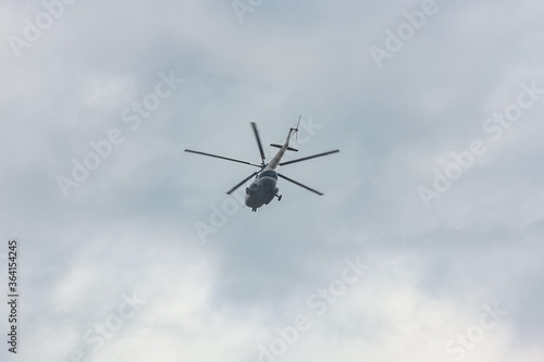 helicopter with five blades flies in the sky. View from the bottom. Fast air transport in cloudy sky.