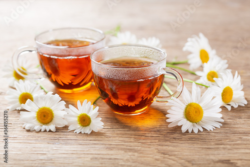 cups of herbal chamomile tea with fresh chamomile flowers