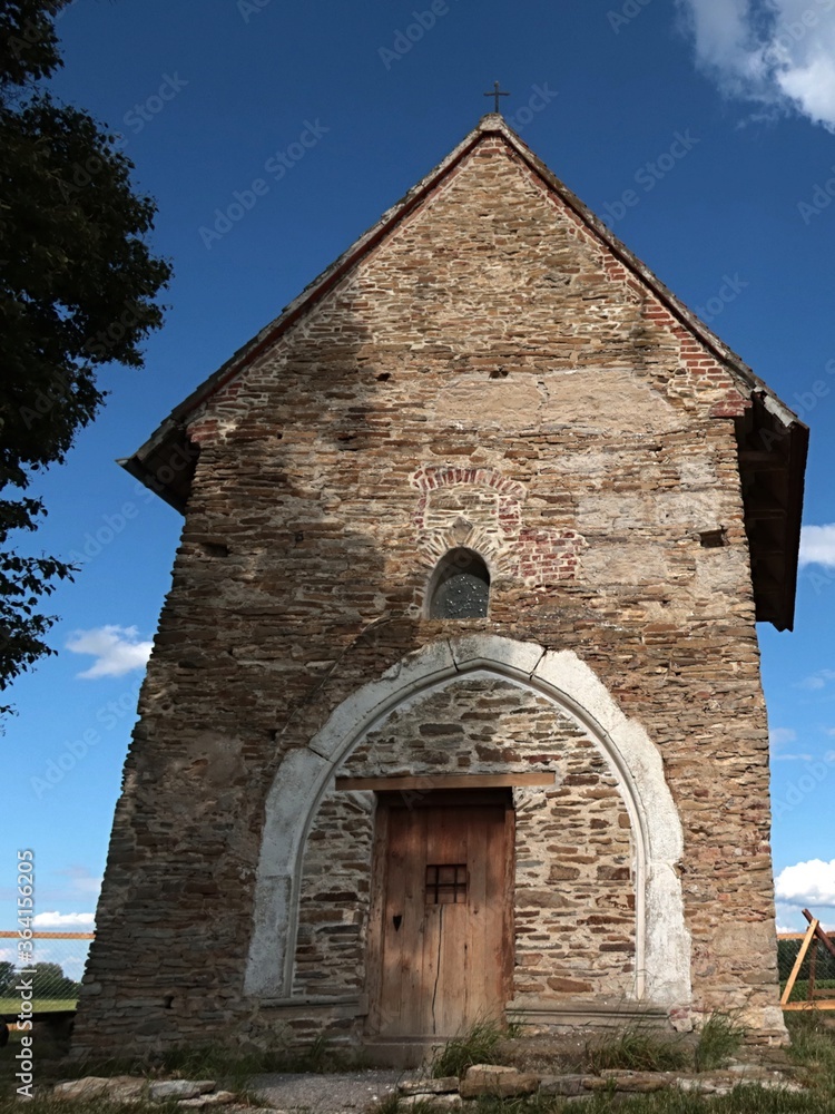 Fototapeta premium Front view of pre-romanese Church of Saint Margaret of Antioch, Kopcany, on boundary between Czech Republic and Slovakia, near Morava river, in summer daylight sunshine. 