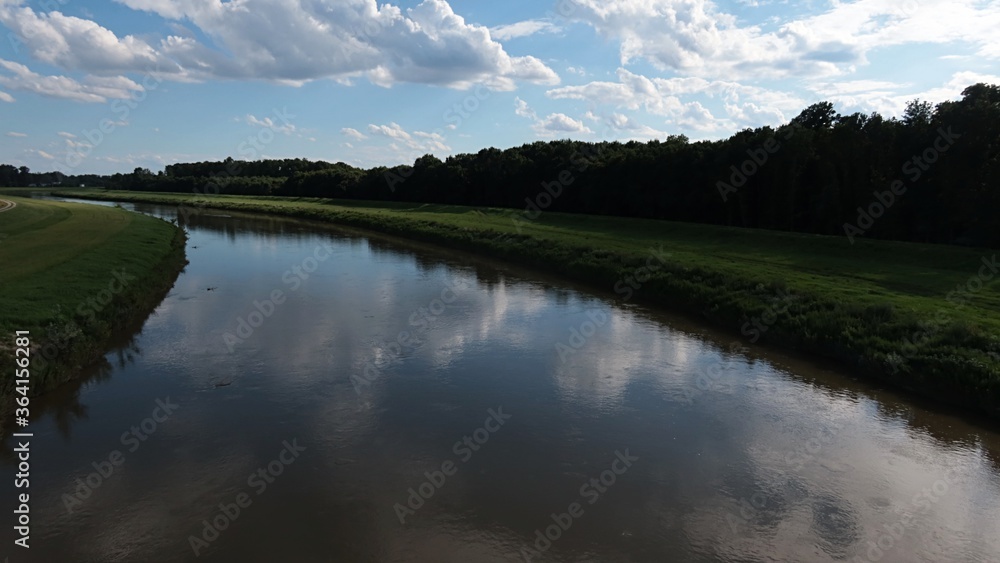 Curve of river Morava bank near new bridge between Mikulcice town on Czech side and  Kopcany on Slovak side, during early summer season, cloudy skies reflection visible inreflection visible in water. 