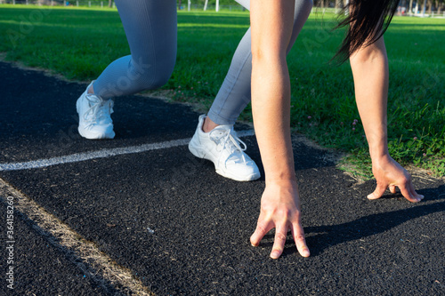 athletic girl jogging at stadium . low start. a head start. fir girl at football field