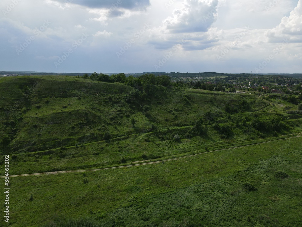Fototapeta premium Aerial view of green hills on a cloudy day