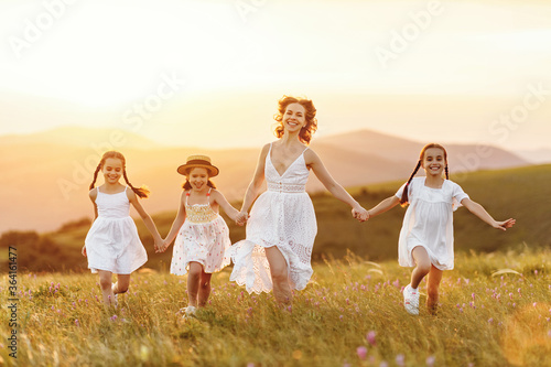 Happy mother with daughters having fun in countryside