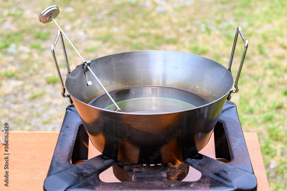 Pentola con olio per frittura e termometro per misurare la giusta  temperatura dell'olio messa sul fornello Stock Photo | Adobe Stock