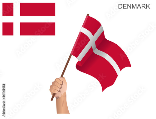 Danish country's flag raised with a stick held by hand to ignite the spirit of statehood