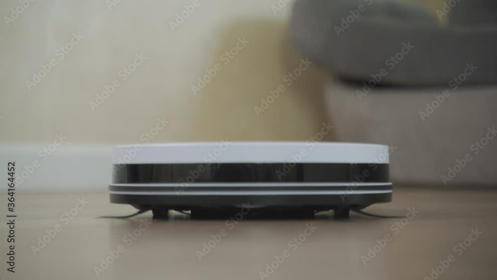 Robot cleaner cleans the room. Smart home. Robot vacuum cleaner performs automatic cleaning of the apartment Robot cleaner cleans the room. Smart home. Robot vacuum cleaner performs automatic cleaning of the apartment