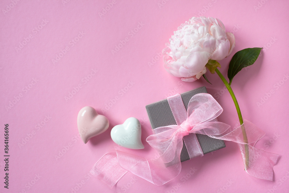 Pink background with peony, hearts and box with a gift, space for text, congratulations Pink background with peony, hearts and box with a gift, space for text, congratulations