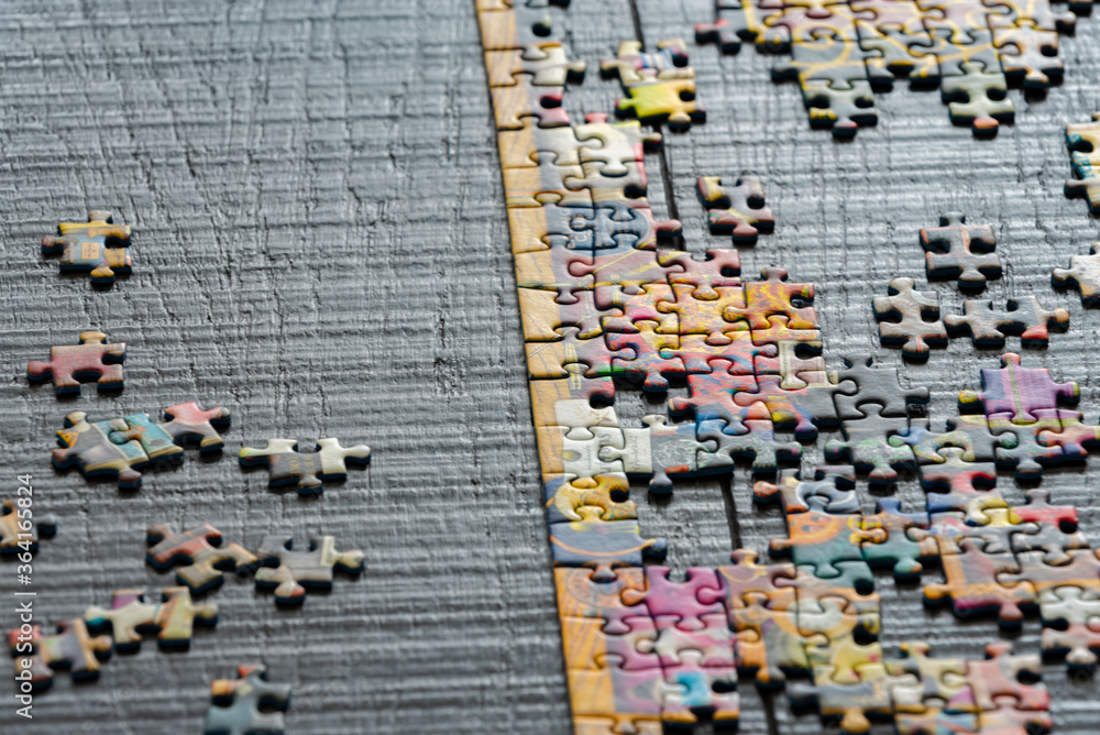 Fototapeta premium A partially completed puzzle on wood table