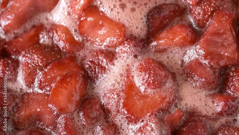The process of making strawberry jam in its own juice with the addition of sugar in an open bowl on a gas stove macro video shooting The process of making strawberry jam in its own juice with the addition of sugar in an open bowl on a gas stove macro video shooting