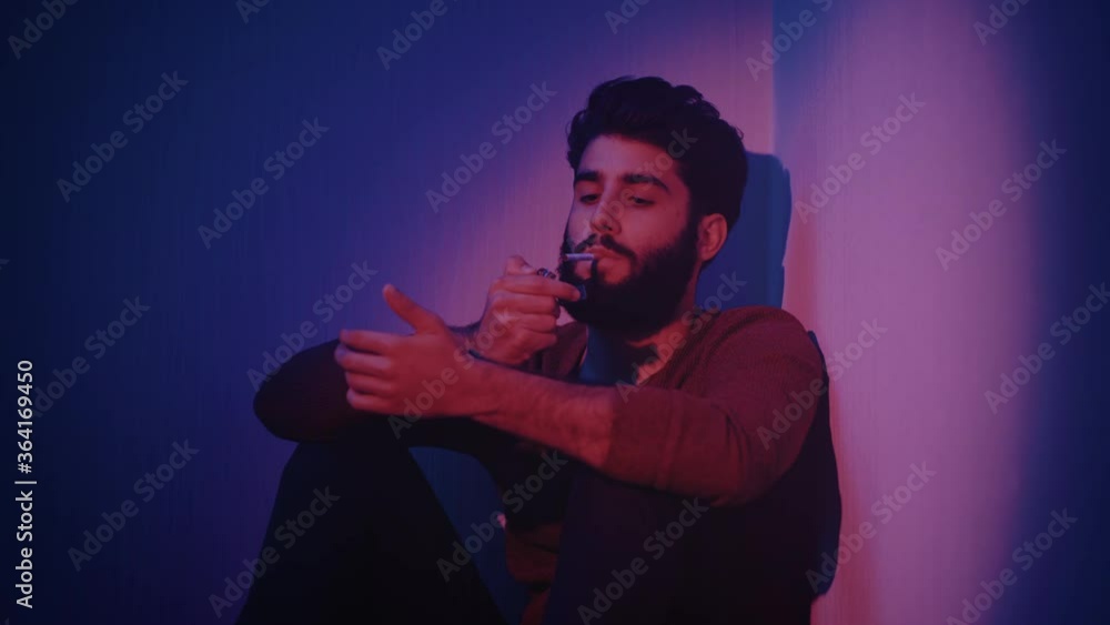 Man sitting in a corner smoking Man sitting in a corner smoking