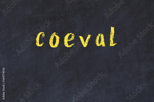 Fotografi College chalk desk with the word coeval written on in