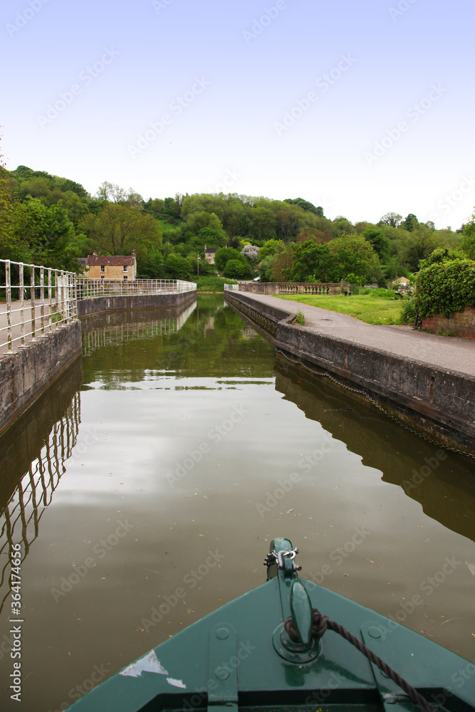 Fototapeta premium Beautiful canal in United Kingdom, featuring trees, water and boats