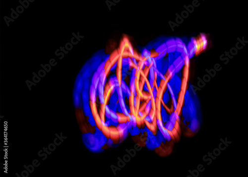 light painting abstract background. curves and waves of purple and red light against a black background