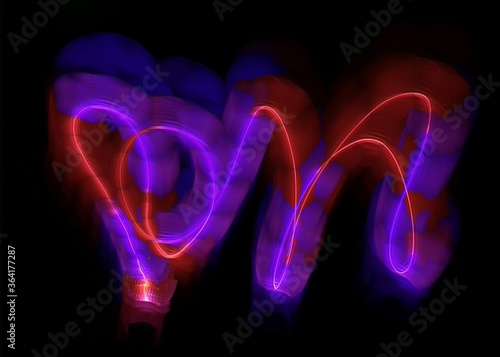 light painting abstract background. curves and waves of purple and red light against a black background
